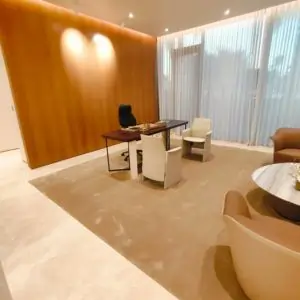 A modern office carpet in dubai featuring a large table surrounded by several chairs, designed for collaboration and meetings.