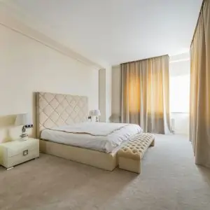 A spacious bedroom featuring beige walls and carpet, designed for comfort in a Dubai setting.