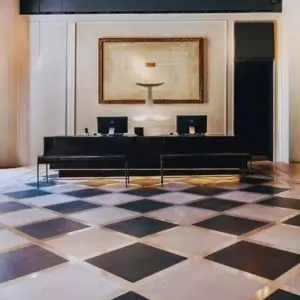 Hotel lobby featuring a stylish checkered floor, with seating areas and a welcoming atmosphere.