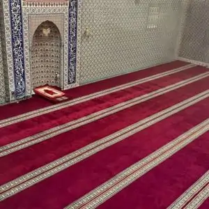 Interior of a mosque in Dubai featuring a vibrant red carpet covering the floor.