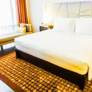 A hotel room featuring a bed, a chair, and a plush carpet in Dubai .